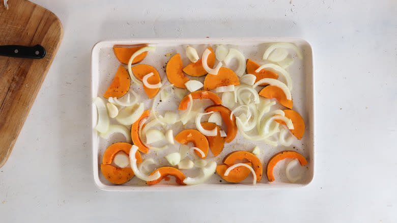 onions, squash, and garlic on a sheet pan