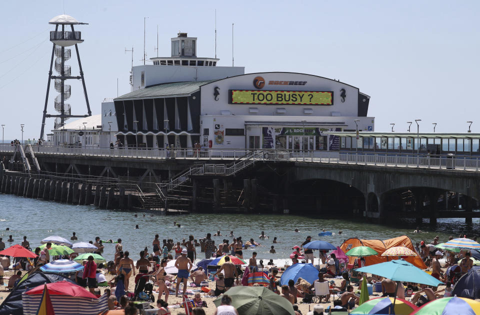 Crowds gather on the beach in Bournemouth, England, Thursday June 25, 2020, as coronavirus lockdown restrictions have been relaxed. According to weather forecasters Thursday could be the UK's hottest day of the year, so far, with scorching temperatures forecast to rise even further. (Andrew Matthews/PA via AP)