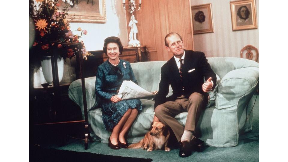 Queen Elizabeth ll and Prince Phillip the Duke of Edinburgh relaxing with their corgis and newspapers at Balmoral in 1975