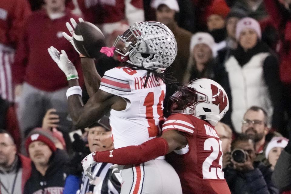 Ohio State's Marvin Harrison Jr. (18) cqatches a pass with Wisconsin's Jason Maitre (23) defending during the first half of an NCAA college football game Saturday, Oct. 28, 2023, in Madison, Wis. (AP Photo/Morry Gash)