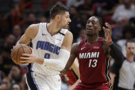 Orlando Magic center Nikola Vucevic (9) looks for an opening past Miami Heat forward Bam Adebayo (13) during the first half of an NBA basketball game Wednesday, March 4, 2020, in Miami. (AP Photo/Wilfredo Lee)