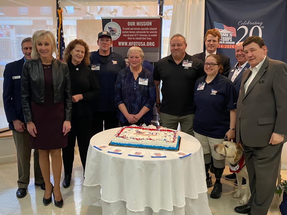 Elected officials, veterans and their families are on hand to cut the cake at the 20th anniversary celebration of Homes for our Troops in the organization's Taunton headquarters on Tuesday, Feb. 6, 2024.