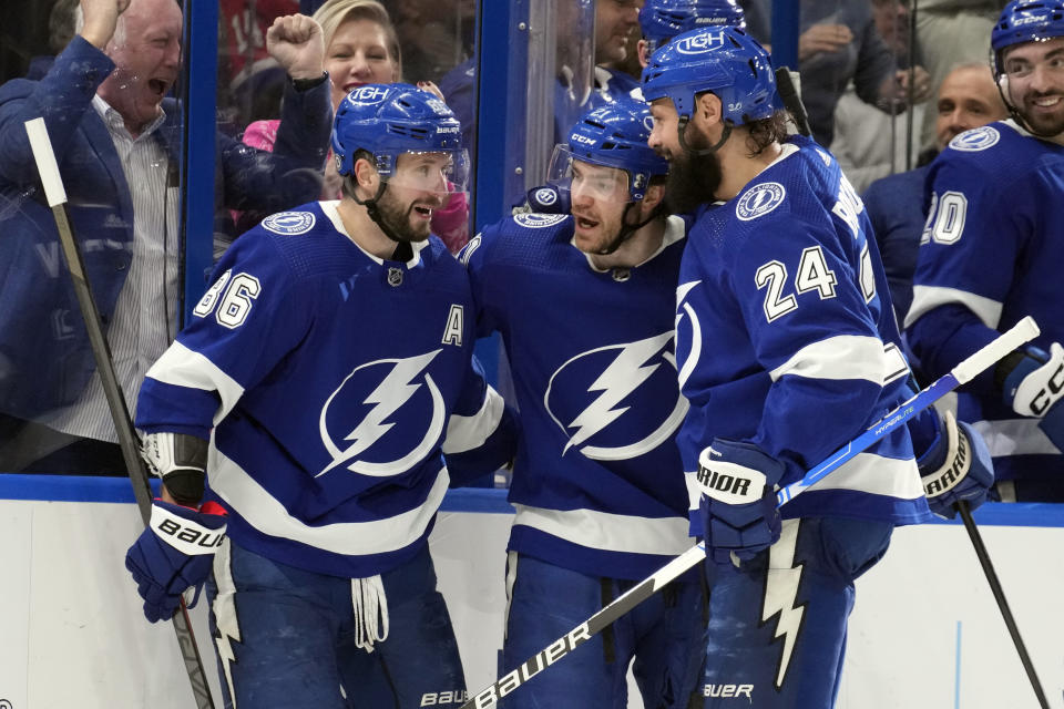 Tampa Bay Lightning center Brayden Point (21) celebrates his goal against the Montreal Canadiens with right wing Nikita Kucherov (86) and defenseman Zach Bogosian (24) during the second period of an NHL hockey game Wednesday, Dec. 28, 2022, in Tampa, Fla. (AP Photo/Chris O'Meara)