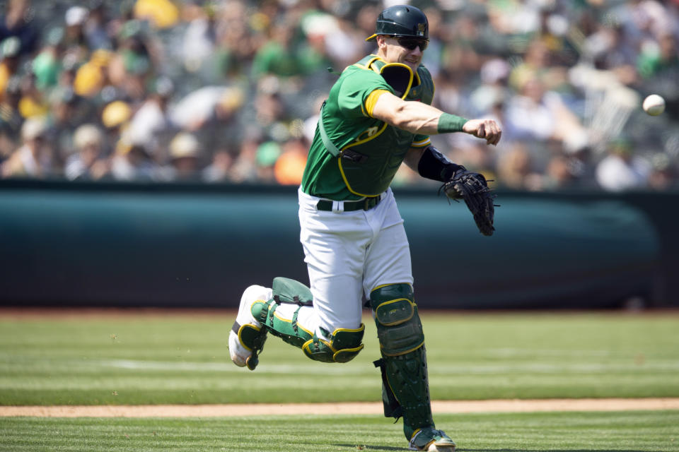 Oakland Athletics catcher Sean Murphy (12) throws out Texas Rangers' Adolis García on a bunt attempt during the sixth inning of a baseball game, Sunday, Aug. 8, 2021, in Oakland, Calif. (AP Photo/D. Ross Cameron)