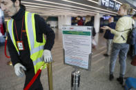 A notice explaining precautions to be taken by people traveling to Wuhan, China, is seen at a terminal of Rome's International Fiumicino airport, Tuesday, Jan. 21, 2020. Heightened precautions are being taken worldwide as a new strain of coronavirus has been infecting hundreds of people across the central Chinese metropolis. (AP Photo/Gregorio Borgia)