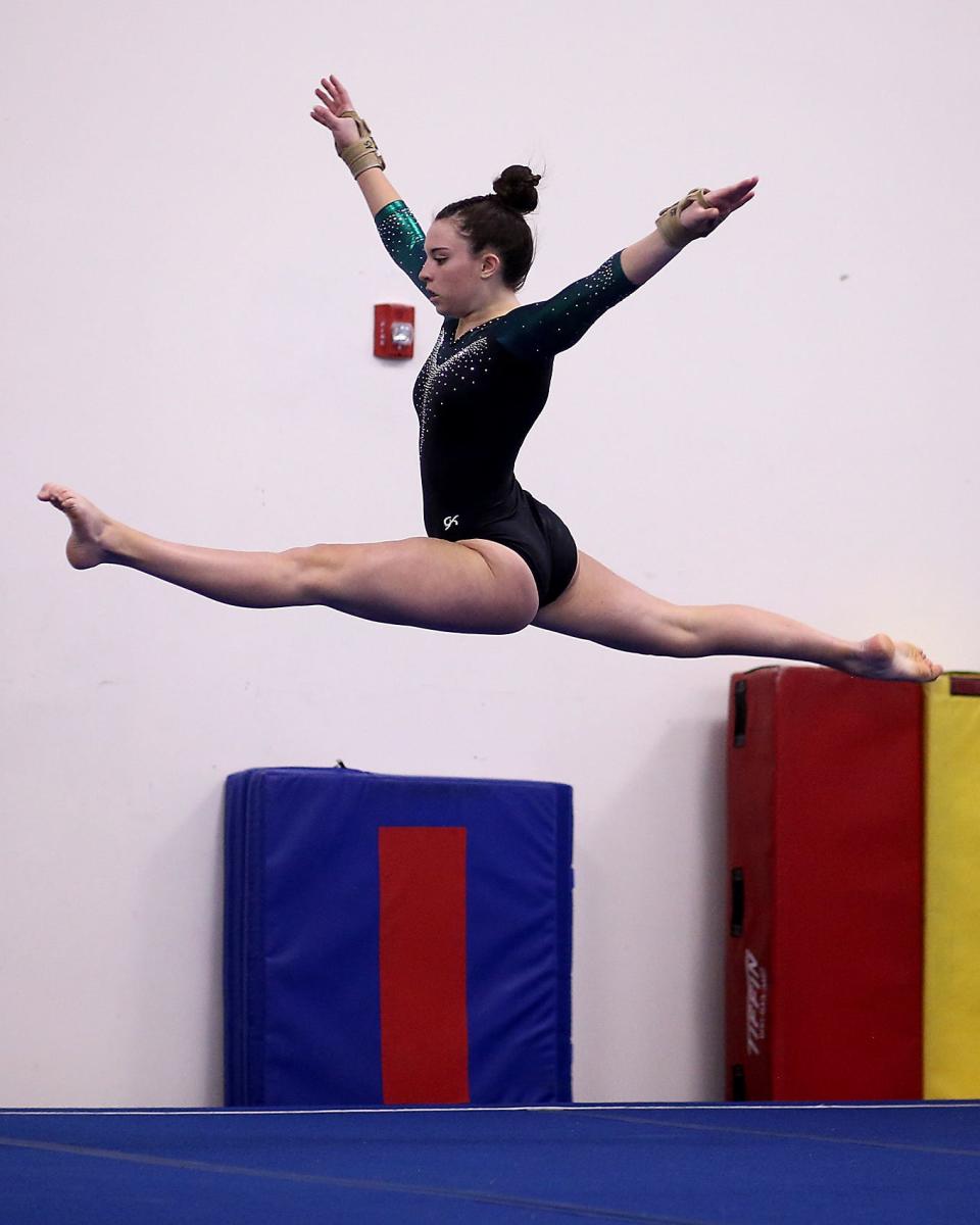 Marshfield’s Annie Spencer leaps out while performing on the floor in their meet against Scituate at the South Shore YMCA Gymnastics Center in Hanover on Friday, Jan. 20,  2023. 