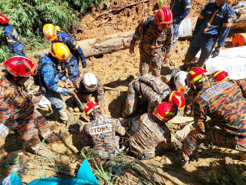 Rescatistas trabajan durante una operación de rescate y evacuación tras un deslizamiento de tierras en un campamento en Batang Kali, estado de Selangor, en las afueras de Kuala Lumpur, Malasia