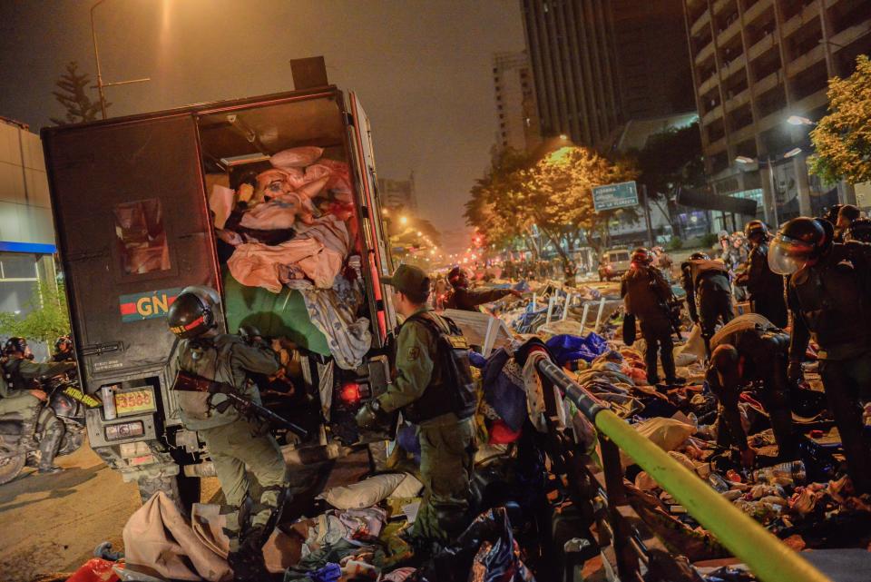 Bolivarian National Guard soldiers load a truck with students belongings as they dismantle student encampments outside of UN headquarters in Caracas, Venezuela, Thursday, May 8, 2014. Hundreds of security forces broke up four camps maintained by student protesters, arresting more than 200 people in a pre-dawn raid. The camps of small tents were installed more than a month ago in front of the UN building and other anti-government strongholds in the capital to protest against President Nicolas Maduro's government. (AP Photo/Carlos Becerra)