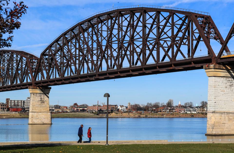 A couple walk near the Big Four Bridge at Waterfront Park Tuesday afternoon.  Gov. Andy Beshear said he wants to budget $10 million over two years to expand Waterfront Park into Louisville's West End. Nov. 30, 2021 