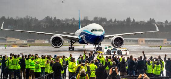 Boeing employees and family members cheer the 777X after it landed at Boeing Field in Seattle (AP)