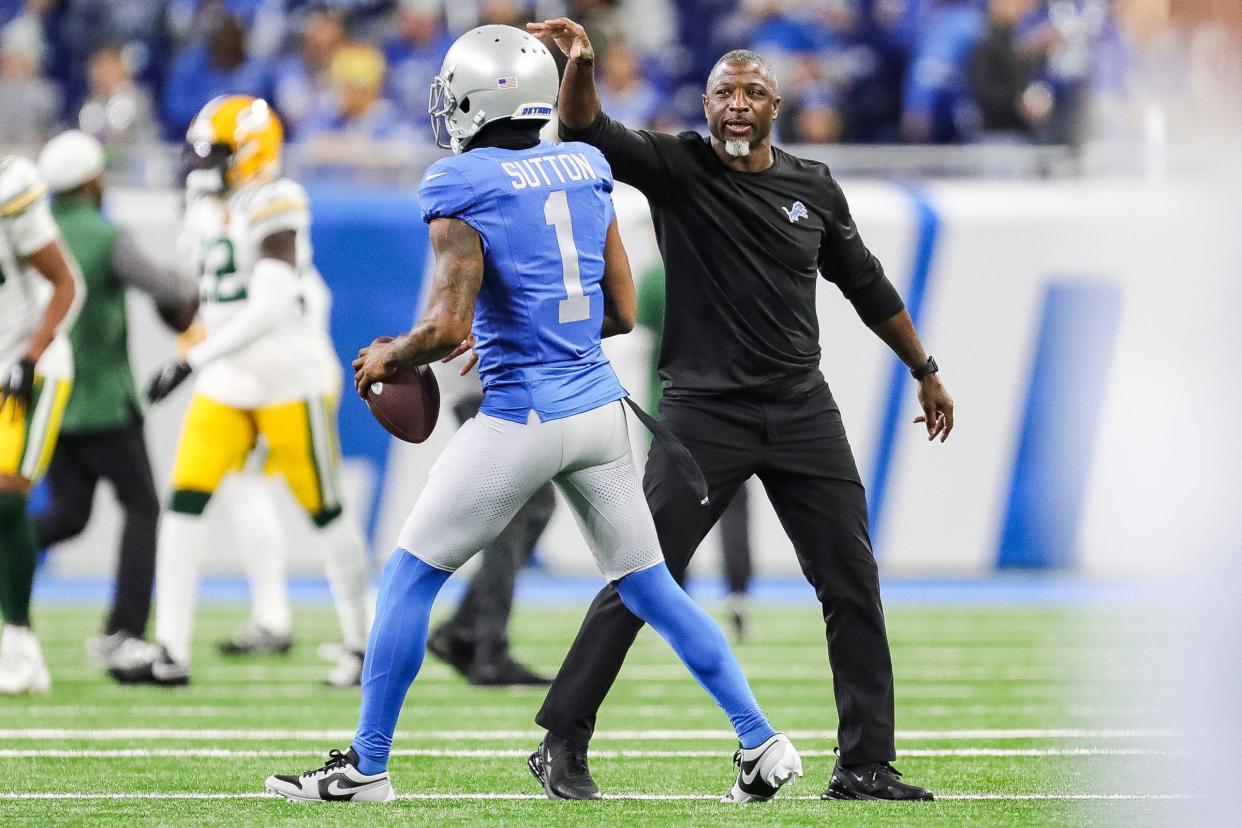 Detroit Lions defensive coordinator Aaron Glenn high-fives cornerback Cam Sutton during warmups before a game against the Green Bay Packers at Ford Field in Detroit on Thursday, Nov. 23, 2023.