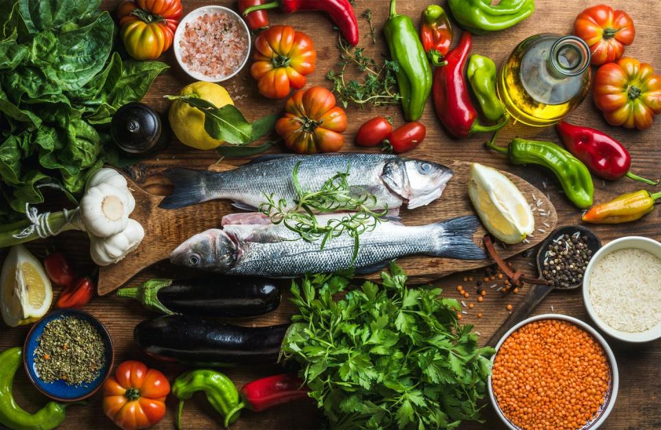 Pescado , pimientos, tomates, perejil y otros alimentos típicos de la dieta mediterránea.