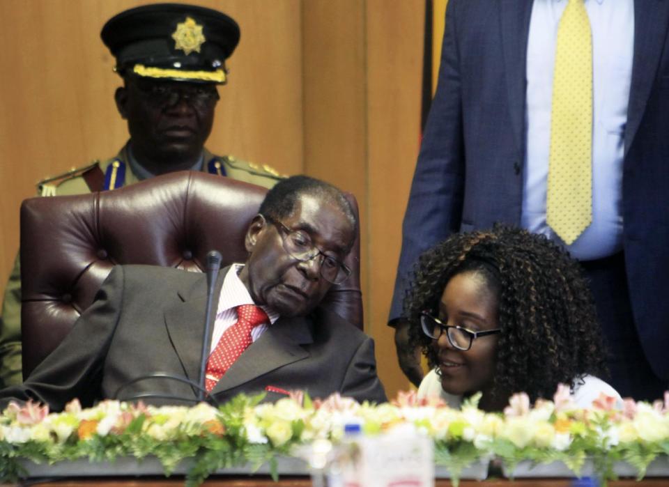 Zimbabwe's President Robert Mugabe talks to his daughter Bona as he marks his 93rd birthday at his offices in Harare, Tuesday, Feb. 21, 2017. Mugabe described his wife Grace, an increasingly political figure, as "fireworks" in an interview marking his 93rd birthday. (AP Photo/Tsvangirayi Mukwazhi)