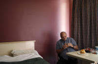 In this Oct. 11, 2018, photo, Dave Frazier eats lunch by a bed in his room at the Fireside Inn motel in Reno, Nev. (AP Photo/John Locher)