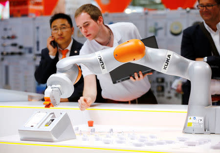 FILE PHOTO: A Kuka technician programs a robot arm of German industrial robot maker Kuka at the company's stand during the Hannover Fair in Hanover, Germany April 25, 2016. REUTERS/Wolfgang Rattay/File Photo