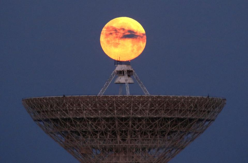 The moon seen through clouds behind the radio telescope RT-70 in the village of Molochnoye, Crimea (Reuters)