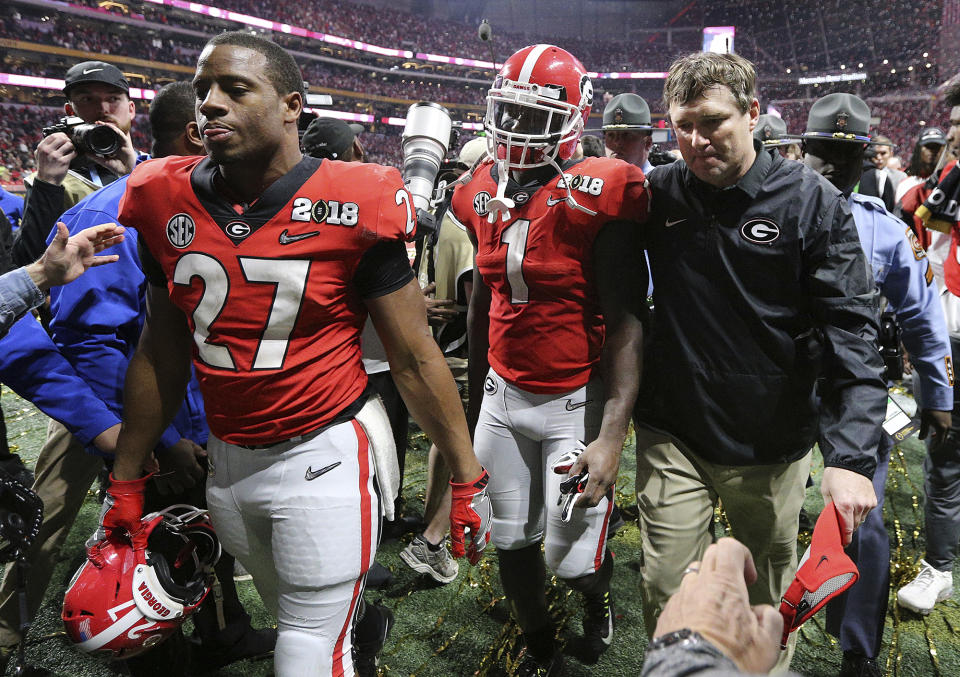 Georgia’s Nick Chubb, from left, Sony Michel and Kirby Smart walk off the field as Georgia loses to Alabama in the NCAA college football playoff championship game in Atlanta on Monday, Jan. 8, 2018. Alabama won, 26-23. (Curtis Compton/Atlanta Journal-Constitution via AP)