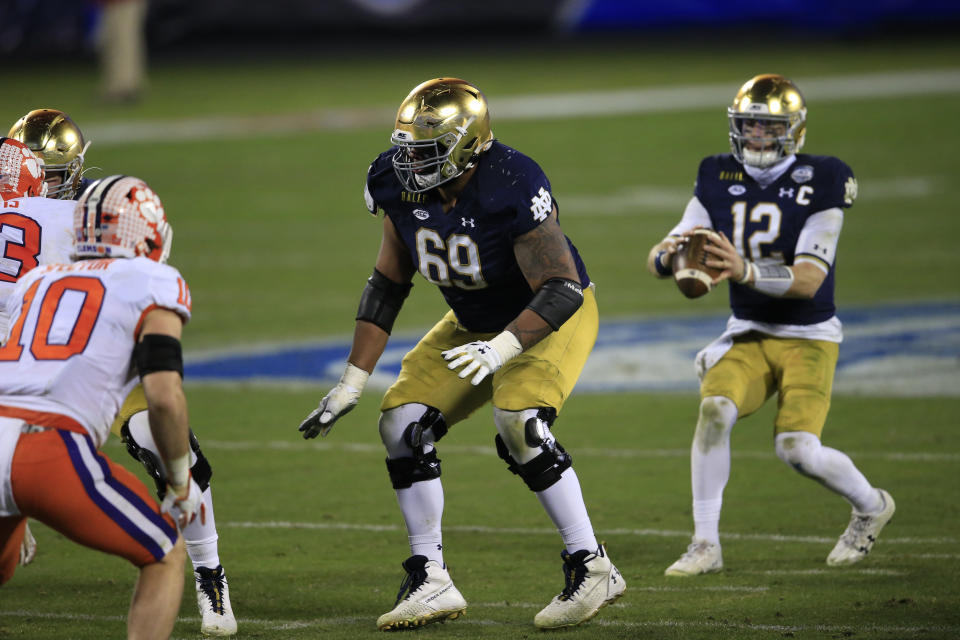 Notre Dame offensive lineman Aaron Banks (69) protects quarterback Ian Book (12) from Clemson linebacker Baylon Spector (10) during the second half of the Atlantic Coast Conference championship NCAA college football game, Saturday, Dec. 19, 2020, in Charlotte, N.C. (AP Photo/Brian Blanco)