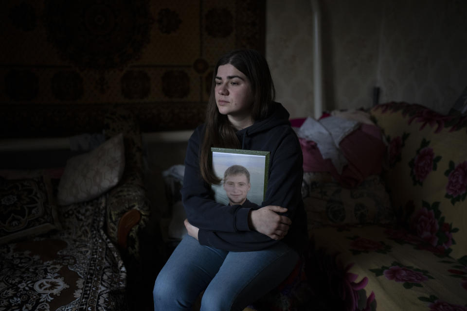 Anna Korostenska abraza una foto de su difunto prometido, Oleksii Zavadskyi, mientras posa para un retrato en la casa de su abuela en Bucha, Ucrania, el jueves 2 de febrero de 2023. Mientras continúa el conflicto que mató a su prometido, Anna lucha con una pregunta con la que toda Ucrania debe lidiar: ¿qué sigue? (AP Foto/Daniel Cole)