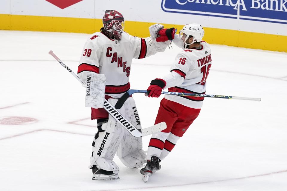 Carolina Hurricanes' Alex Nedeljkovic (39) and Vincent Trocheck (16) celebrate after the team's 4-3 win following a shootout against the Dallas Stars in an NHL hockey game in Dallas, Saturday, Feb. 13, 2021. (AP Photo/Tony Gutierrez)