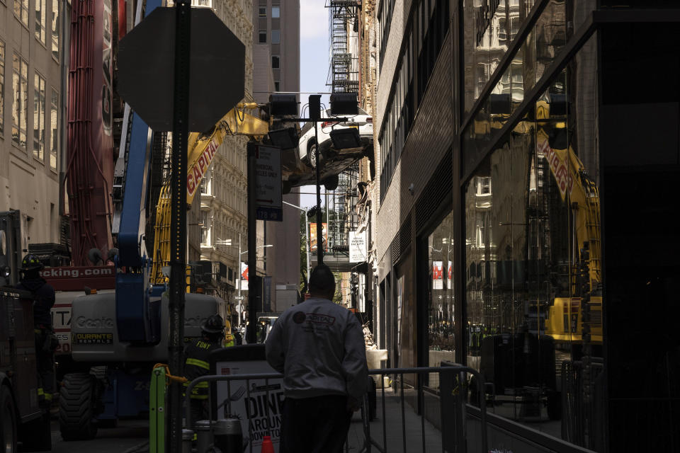 A car is removed from a partially collapsed parking garage in the Financial District of New York, Wednesday, April 19, 2023. (AP Photo/Yuki Iwamura)