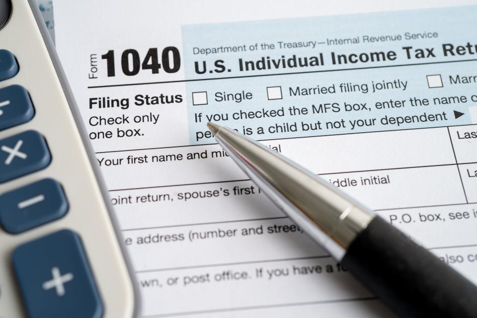 Tax Return form 1040 with USA America flag and dollar banknote, U.S. Individual Income.