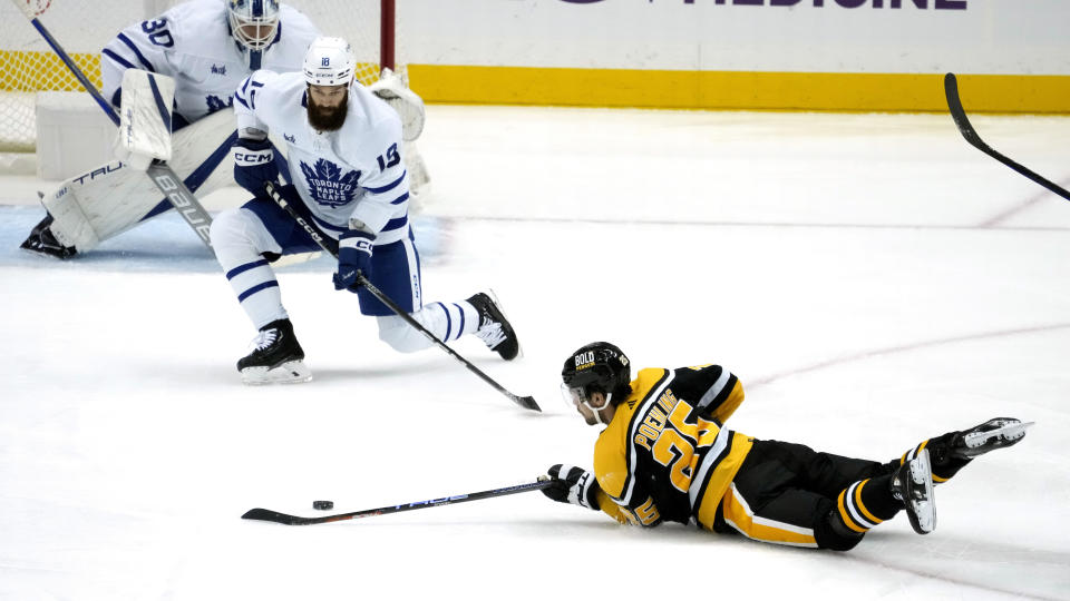 Pittsburgh Penguins' Ryan Poehling (25) attempts to get off a pass after being tripped, with Toronto Maple Leafs' Jordie Benn (18) defending during the first period of an NHL hockey game in Pittsburgh, Tuesday, Nov. 15, 2022. (AP Photo/Gene J. Puskar)