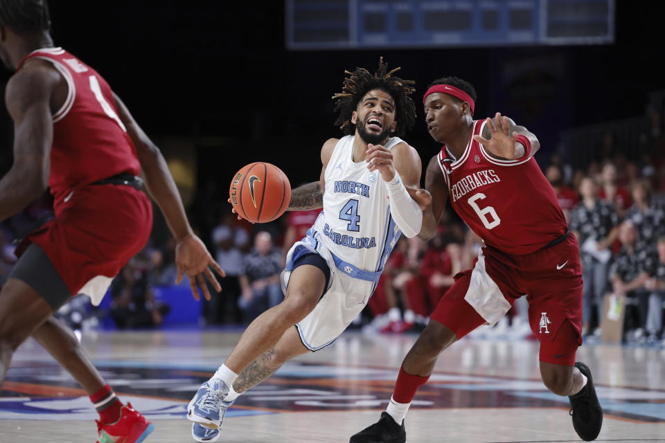 North Carolina's RJ Davis brings the ball up court past Arkansas' Layden Blocker during an NCAA college basketball game in the Battle 4 Atlantis at Paradise Island, Bahamas, Friday, Nov. 24, 2023. (Tim Aylen/Bahamas Visual Services via AP)