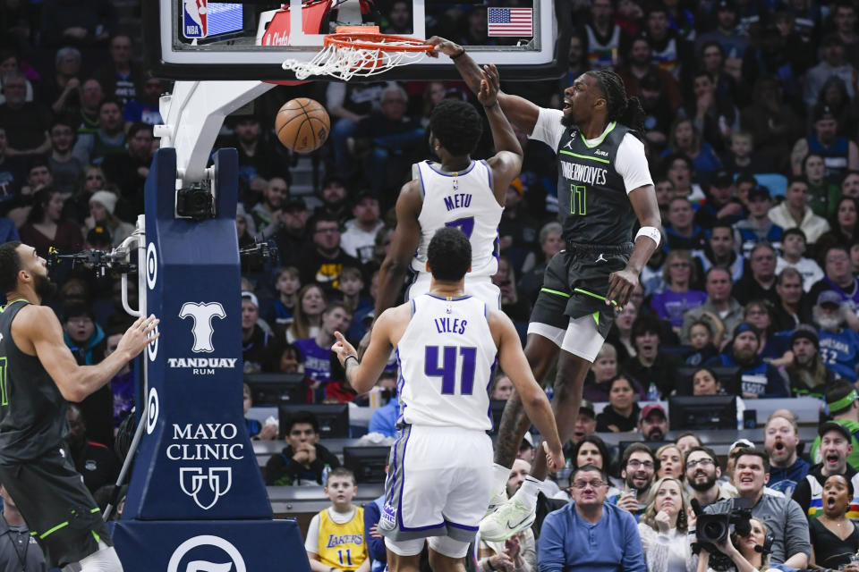 Minnesota Timberwolves center Naz Reid (11) dunks in front of Sacramento Kings forward Chimezie Metu and center Trey Lyles (41) during the second half of an NBA basketball game Saturday, Jan. 28, 2023, in Minneapolis. The Timberwolves won 117-110. (AP Photo/Craig Lassig)