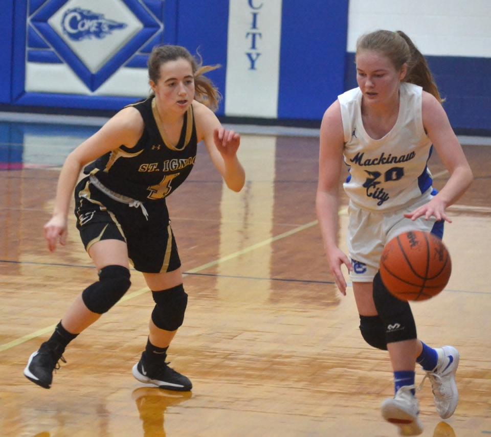 Gracie Beauchamp (right) and the Mackinaw City varsity girls basketball team dropped a contest at St. Ignace on Tuesday night.
