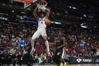 Philadelphia 76ers guard Kelly Oubre Jr. (9) dunks the ball over Miami Heat forward Jimmy Butler (22) and center Bam Adebayo (13) during the first half of an NBA basketball game, Thursday, April 4, 2024, in Miami. (AP Photo/Marta Lavandier)