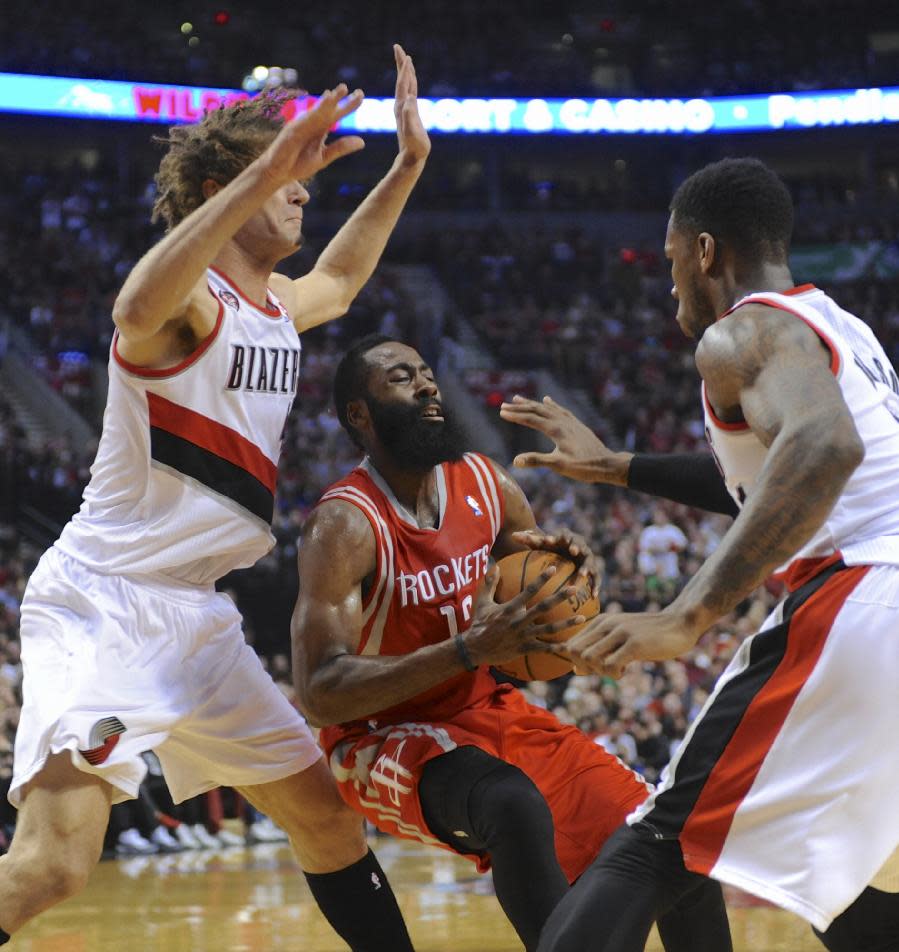 Houston Rockets' James Harden (13) works against Portland Trail Blazers' Thomas Robinson (41) and Robin Lopez (42) during the first half of game six of an NBA basketball first-round playoff series game in Portland, Ore., Friday May 2, 2014. (AP Photo/Greg Wahl-Stephens)