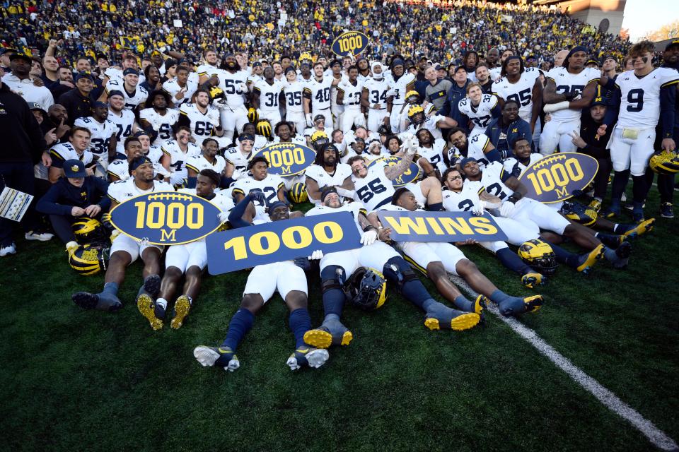 Michigan poses for photographers after a 31-24 win over Maryland that earned the Wolverines their 1,000 win in school history, Saturday, Nov. 18, 2023, in College Park, Md.