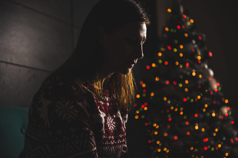 Lonely women sitting on the the sofa at home during christmas