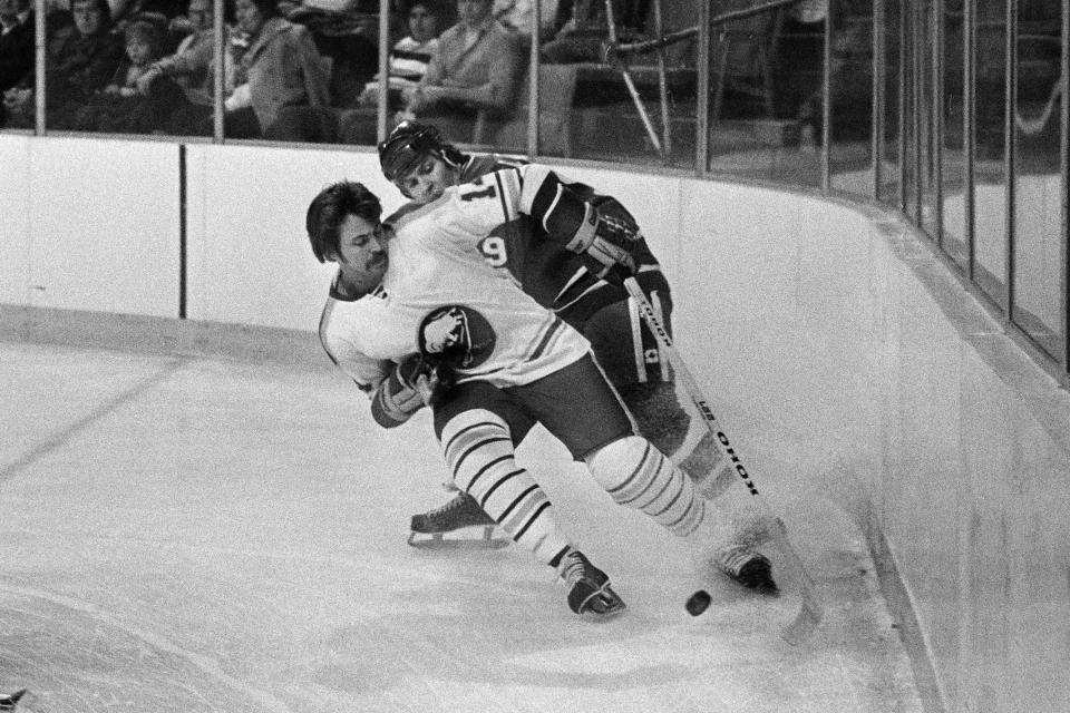 FILE - In this Dec. 12, 1977, file photo, Buffalo Sabres' Rene Robert (14), front, beats Vancouver Canucks' Don Lever (9) to the puck during first period of an NHL hockey game in Buffalo, N.Y. Robert, a retired winger who played on the Sabres' famed "French Connection Line" in the 1970s, was in a Florida hospital on Friday, June 18, 2021, after suffering a heart attack, three people familiar with what happened told The Associated Press. The people spoke on the condition of anonymity because members of Robert's family had requested privacy. (AP Photo/File)