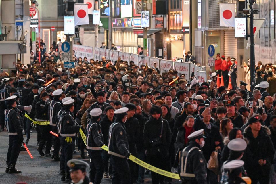 Police cordon pedestrians while they cross Shibuya Crossing in Tokyo on New Year’s Eve ahead of midnight (AFP via Getty Images)