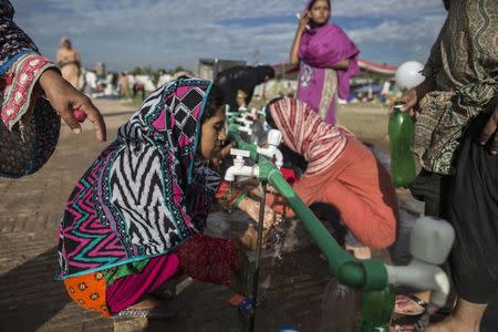 Anti-government protesters wash up in the morning, in front of the President House during the Revolution March in Islamabad September 3, 2014. REUTERS/Zohra Bensemra