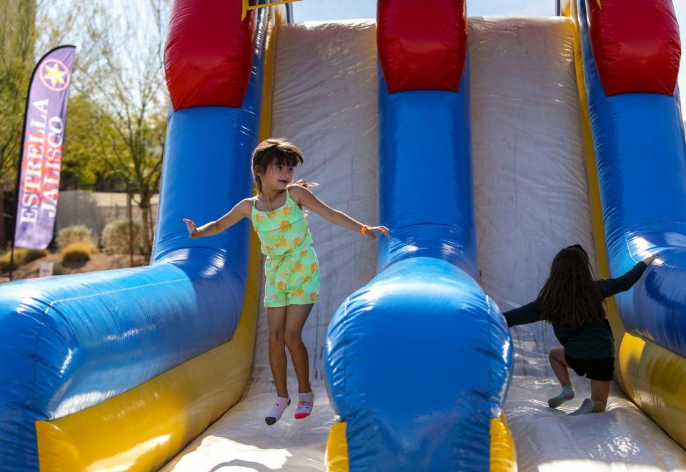 5-year-old Ilyssa Rios (left) of Cathedral City jumps and plays after going down the inflatable slide at the Taste of Jalisco Festival in Cathedral City, Calif., Saturday, Feb. 4, 2023. 