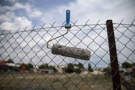 A paint roller is seen attached to a fence in the town of Elefsina, near Athens, Greece June 30, 2015. REUTERS/Marko Djurica