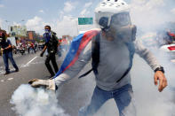 An opposition supporter throws back a tear-gas canister during clashes with security forces in a rally against Venezuela's President Nicolas Maduro in Caracas. REUTERS/Carlos Garcia Rawlins