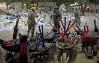 Soldiers, Federal policemen and firefighters remove debris looking for victims in the headquarters of state-owned Mexican oil giant Pemex in Mexico City on February 1, 2013, following a blast inside the building leaving up to now 32 dead and 100 injured