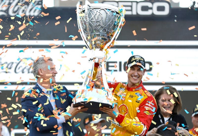 Joey Logano hoisting the NASCAR Cup Series Championship trophy