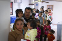 In this Jan. 28, 2020 photo provided by Cronkite News, Arizona State University, Maribel Lopez waits with her family in line to receive vaccinations at Casa del Migrante in San Luis Rio Colorado, Mexico. One Hundred Angels, a Phoenix organization that provides medical care and other services to migrants, helped coordinate the one-day vaccination clinic at Casa del Migrante, working with the Mexican Red Cross. (Delia Johnson/Cronkite News, Arizona State University via AP)