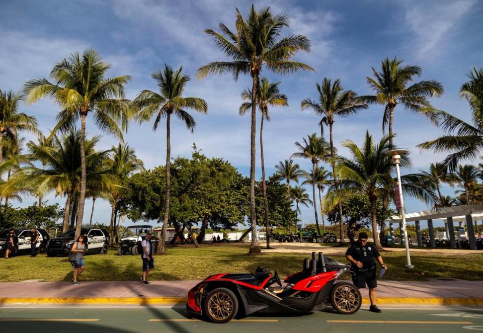 A Miami Beach police officer tickets a vehicle that was traveling in the bike lane along Ocean Drive in South Beach on Feb. 29, 2024.