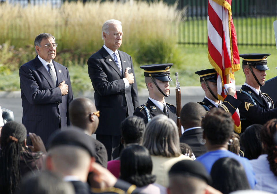 U.S. Defense Secretary Panetta and Vice President Biden hold their hands over their hearts for U.S. National Anthem in Washington