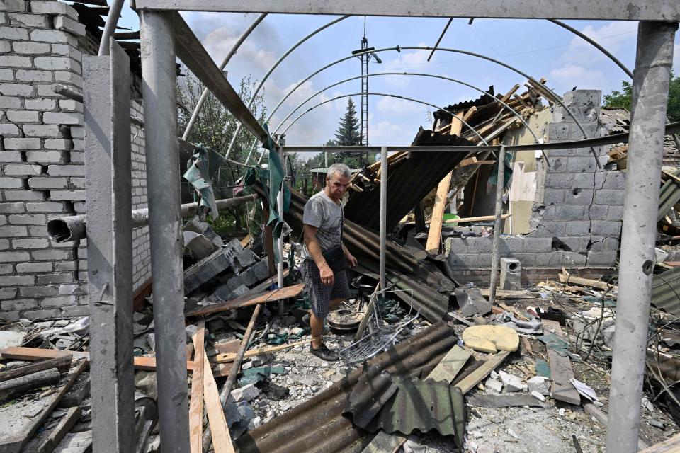 A resident walks among debris next to a destroyed house in Sloviansk (AFP via Getty Images)