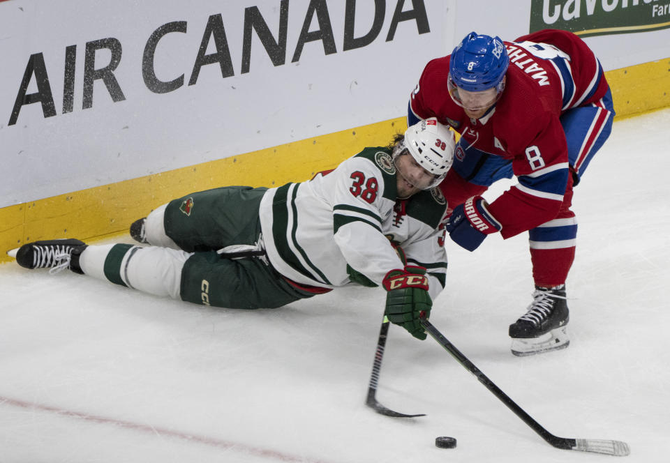 Minnesota Wild's Ryan Hartman (38) and Montreal Canadiens' Mike Matheson (8) battle for the puck during the second period of an NHL hockey game, Tuesday, Oct. 17, 2023 in Montreal. (Christinne Muschi/The Canadian Press via AP)