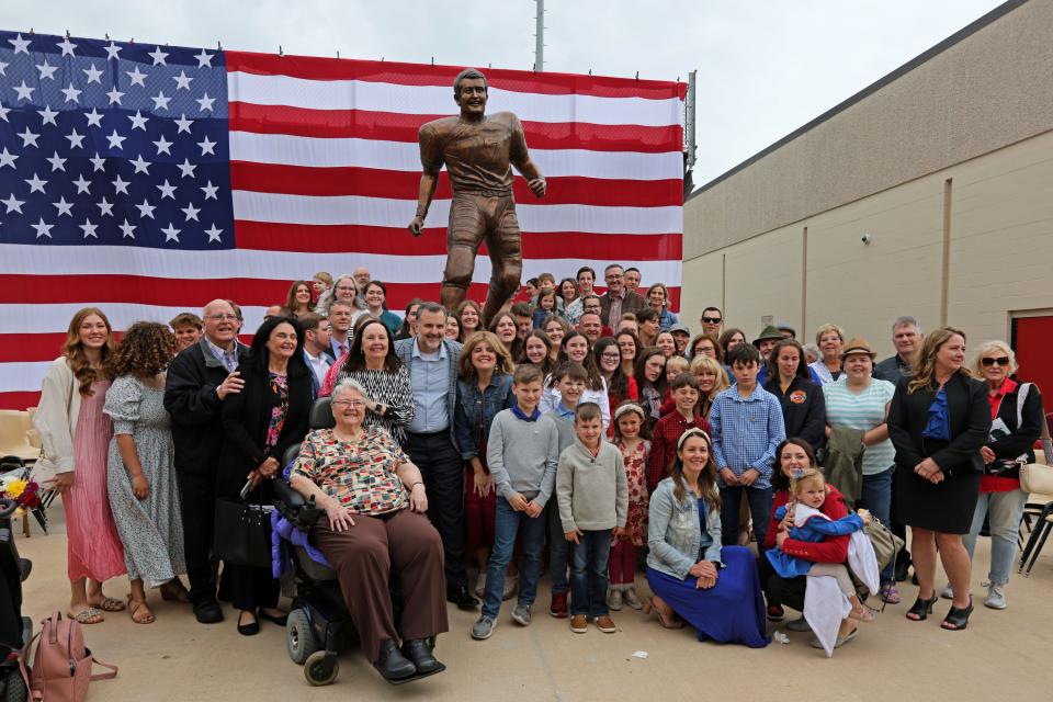 Family of Robert Kalsu pose for a photo after a ceremony to unveil a statue of Robert Kalsu at Robert Kalsu Stadium in Del City, Okla., Friday, March 29, 2024.