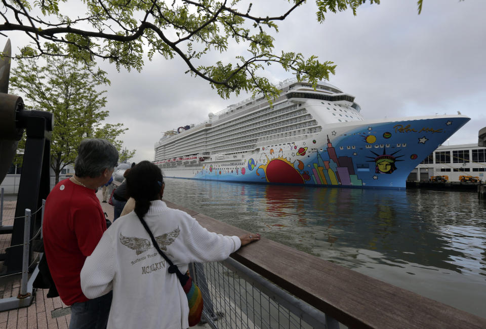 FILE - This May 8, 2013 photo shows people pausing to look at the Norwegian Cruise Line's new ship, Norwegian Breakaway, on the Hudson River, in New York. The ship has a colorful mural on the exterior hull design by pop artist Peter Max featuring the city skyline and the Statue of Liberty. The 2013 cruise season began with a nightmare: A Carnival ship adrift with no power. But in the last month or so, several cruise companies have announced major overhauls to old ships and exciting innovations on new ships, from engineering upgrades to theme park-style rides. (AP Photo/Richard Drew, file)