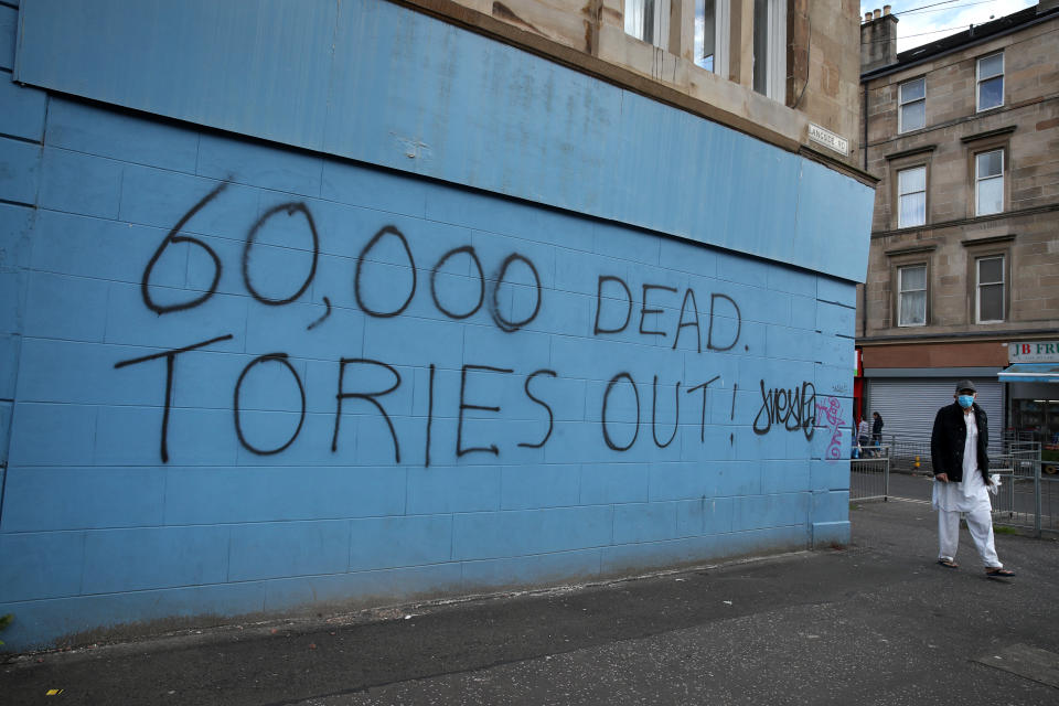 A person passes coronavirus related graffiti in Glasgow as Scotland is moving into phase one of the Scottish Government's plan for gradually lifting lockdown. (Photo by Andrew Milligan/PA Images via Getty Images)